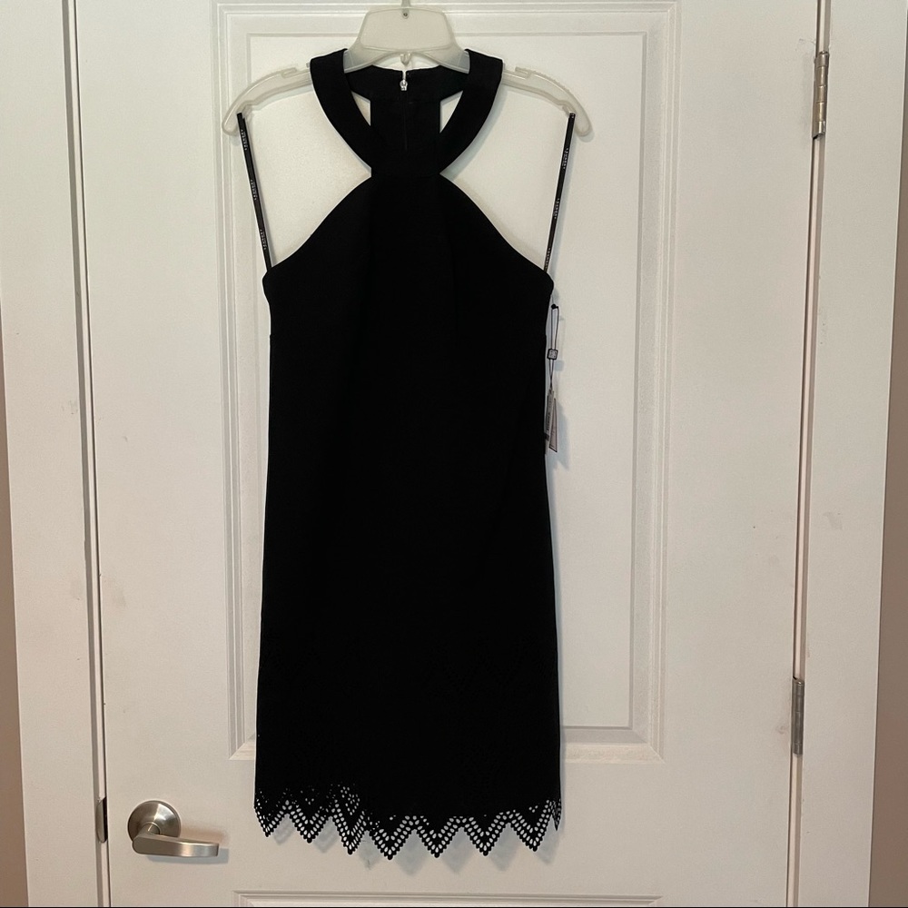 NWT. Black mini dress. Halter style neck and laser cut design along bottom.